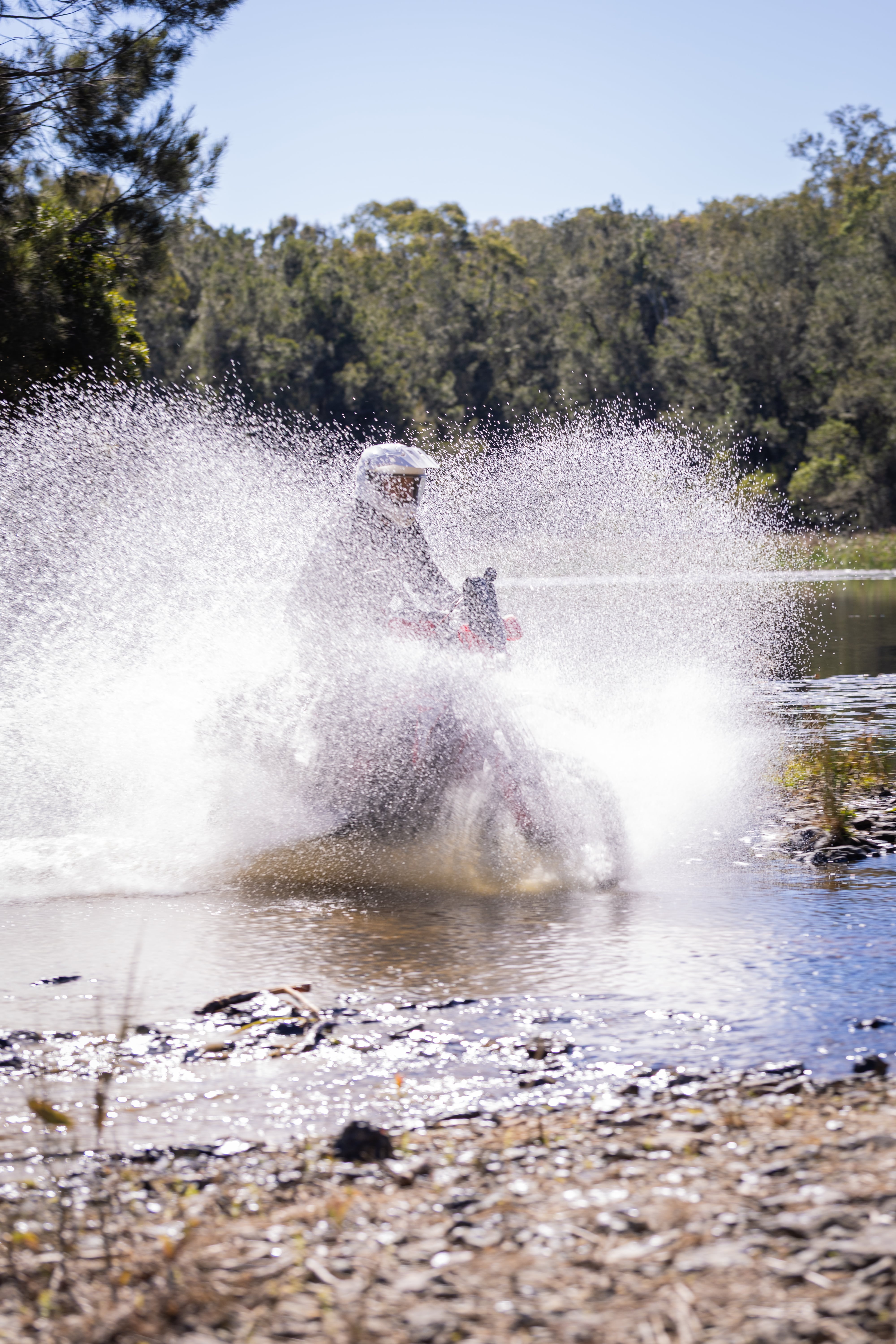 adventure motorcycle riding through a creek crossing