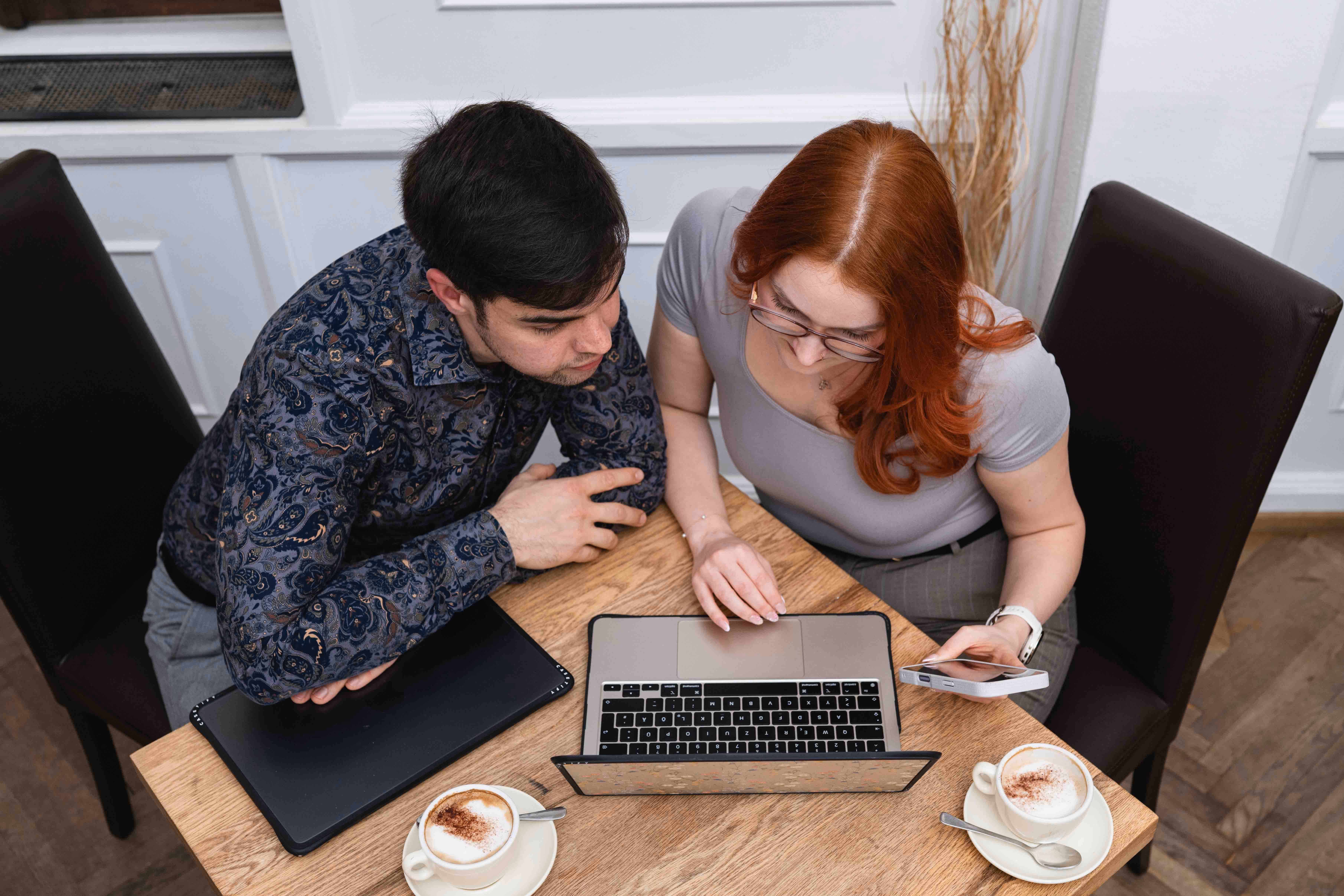 Jennifer und Bernhard schauen gemeinsam auf den Laptop-Bildschirm