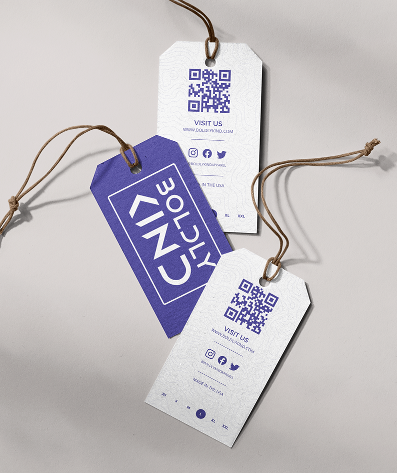 Custom clothing tags for Boldly Kind Apparel showcasing the logo, mission statement, and QR code for conscious shoppers