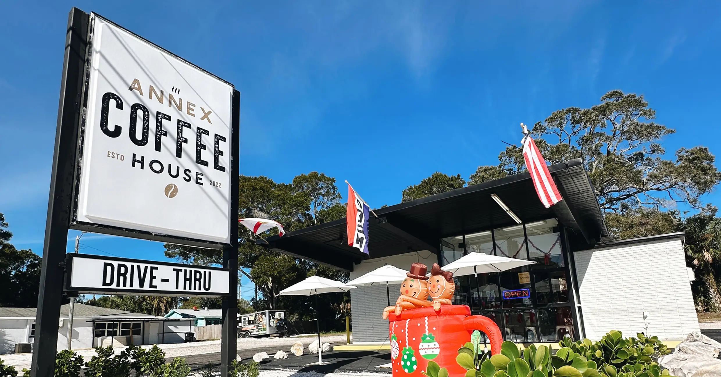 Annex Coffee House exterior signage and drive-thru, photographed on a clear sunny day with flags