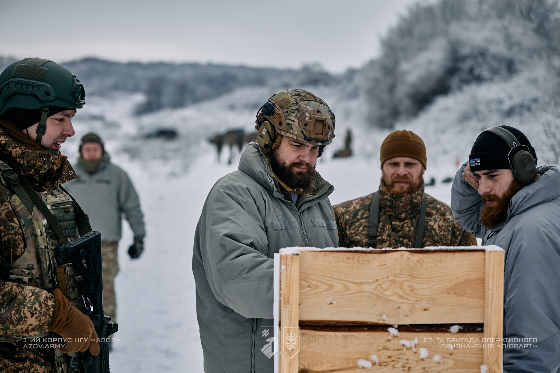 Військовослужбовці разом з інструктором знайомляться з результатами стрільбна зимовому полігоні