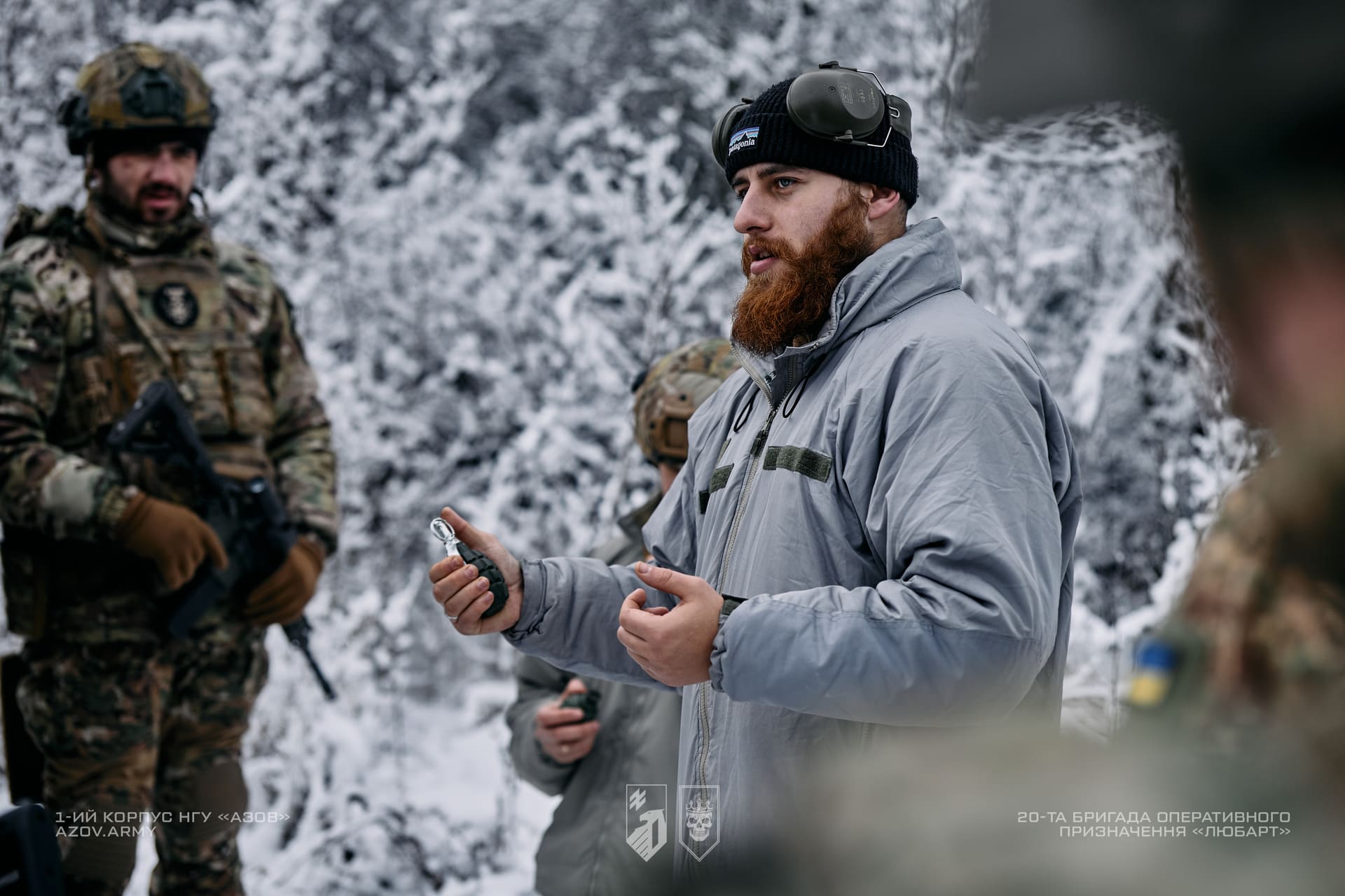Інструктор на зимовому полігоні тримає гранату поряд з військовослужбовцями