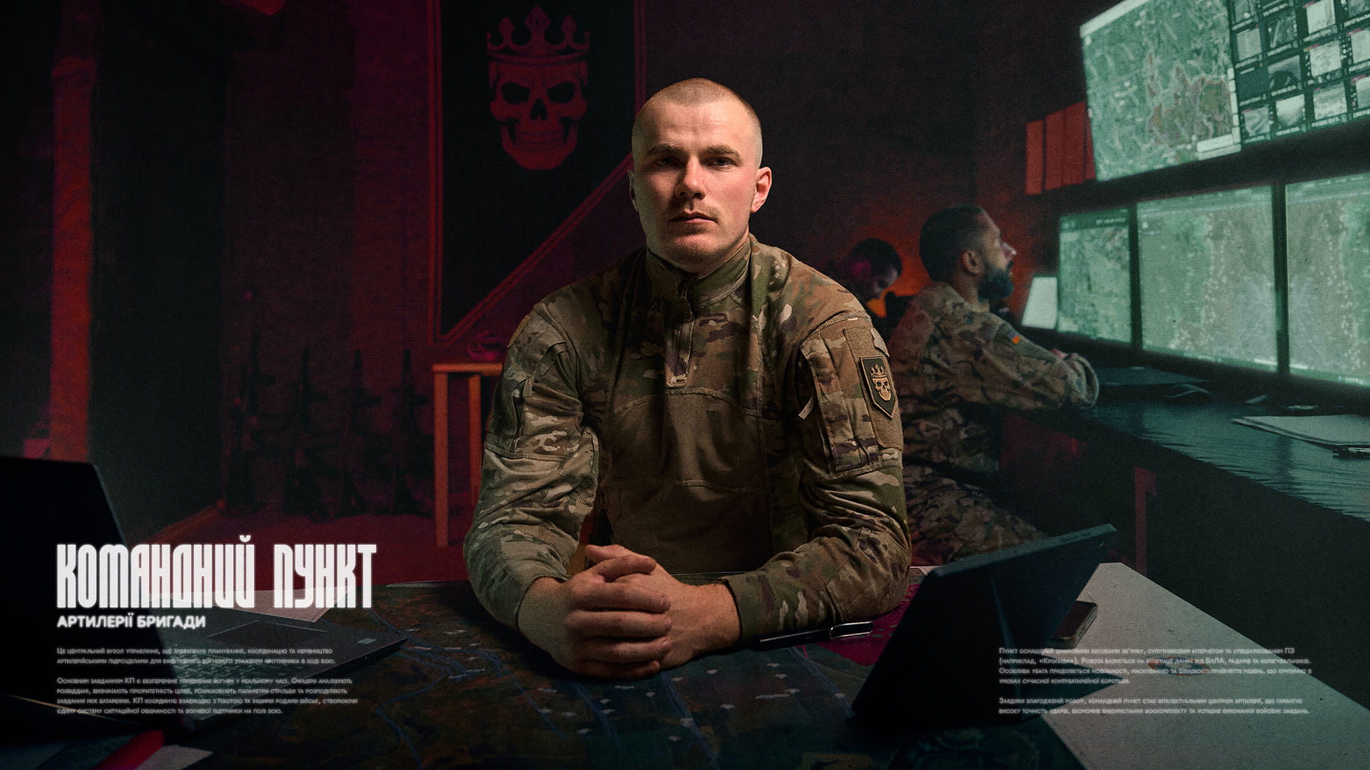 Військовослужбовець за столом на фоні командного пункту