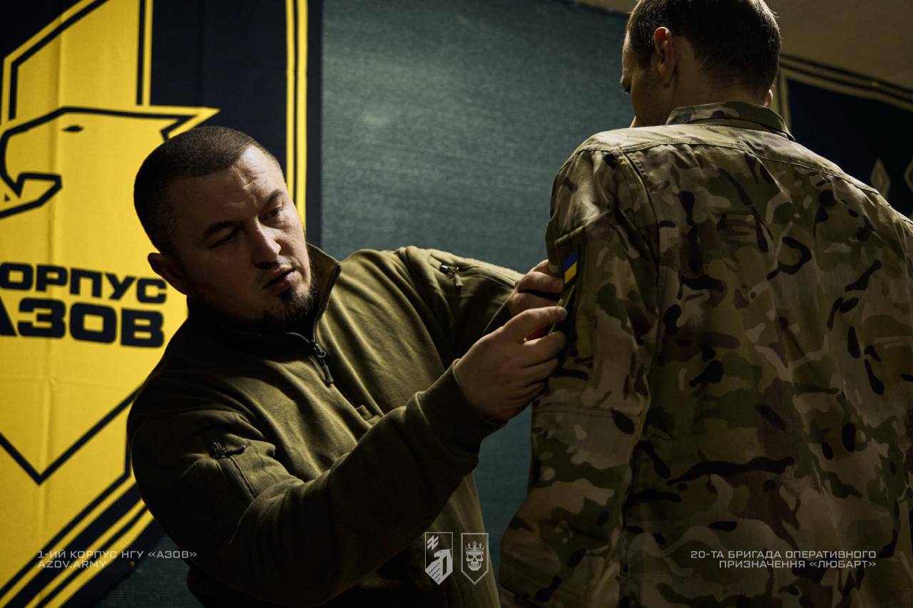 Командир бригади Любарт кріпить шеврон бригади військовослужбовцю