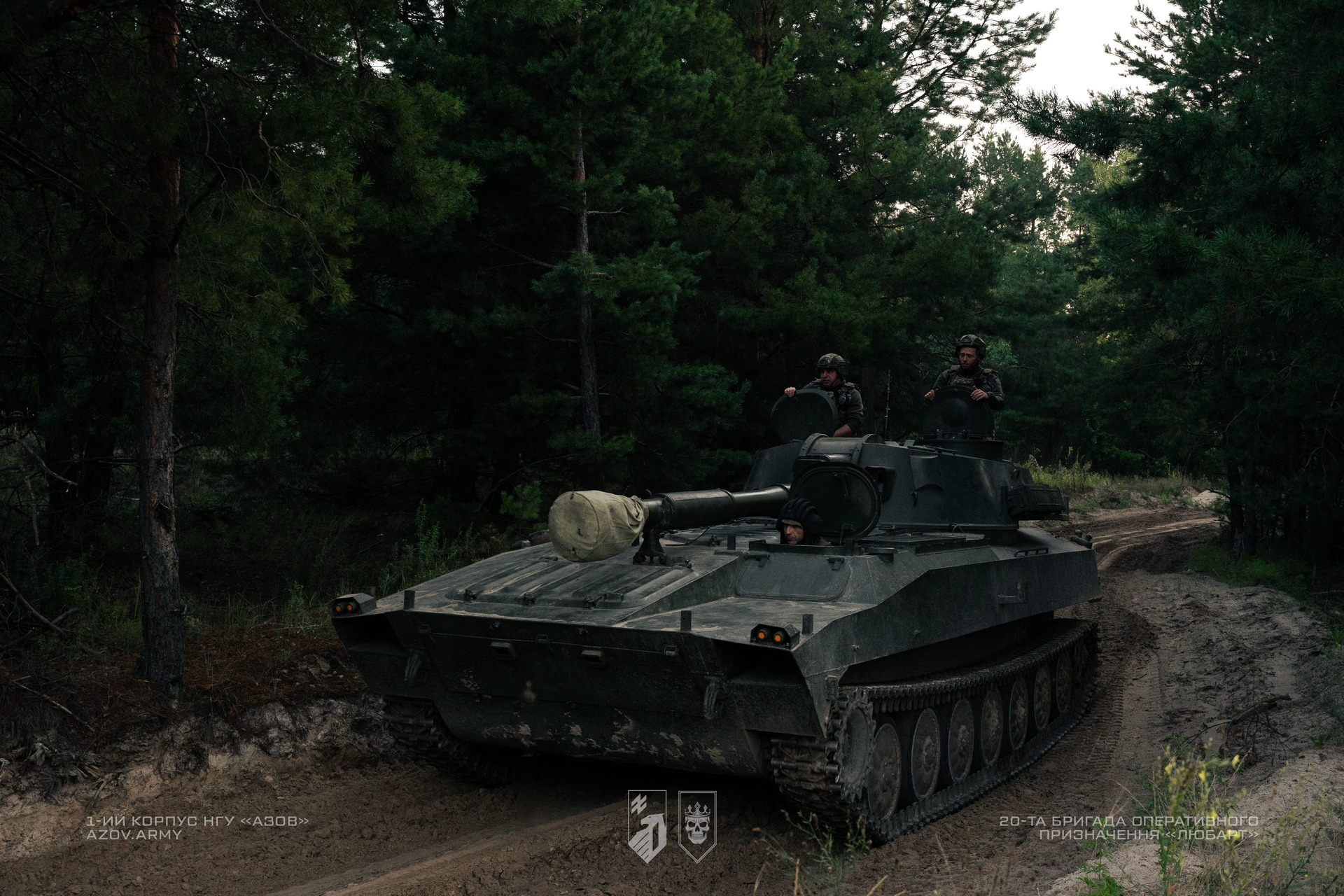 Екіпаж САУ переміщуються по дорозі серед лісу