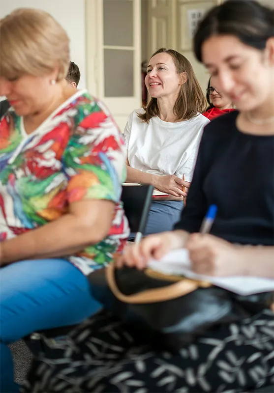 Des femmes sont en train de sourire et assistent à une conférence