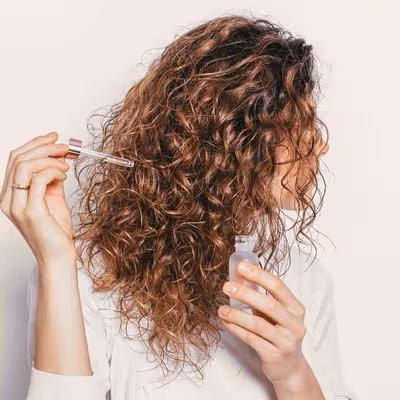 Femme aux cheveux bouclés et fins