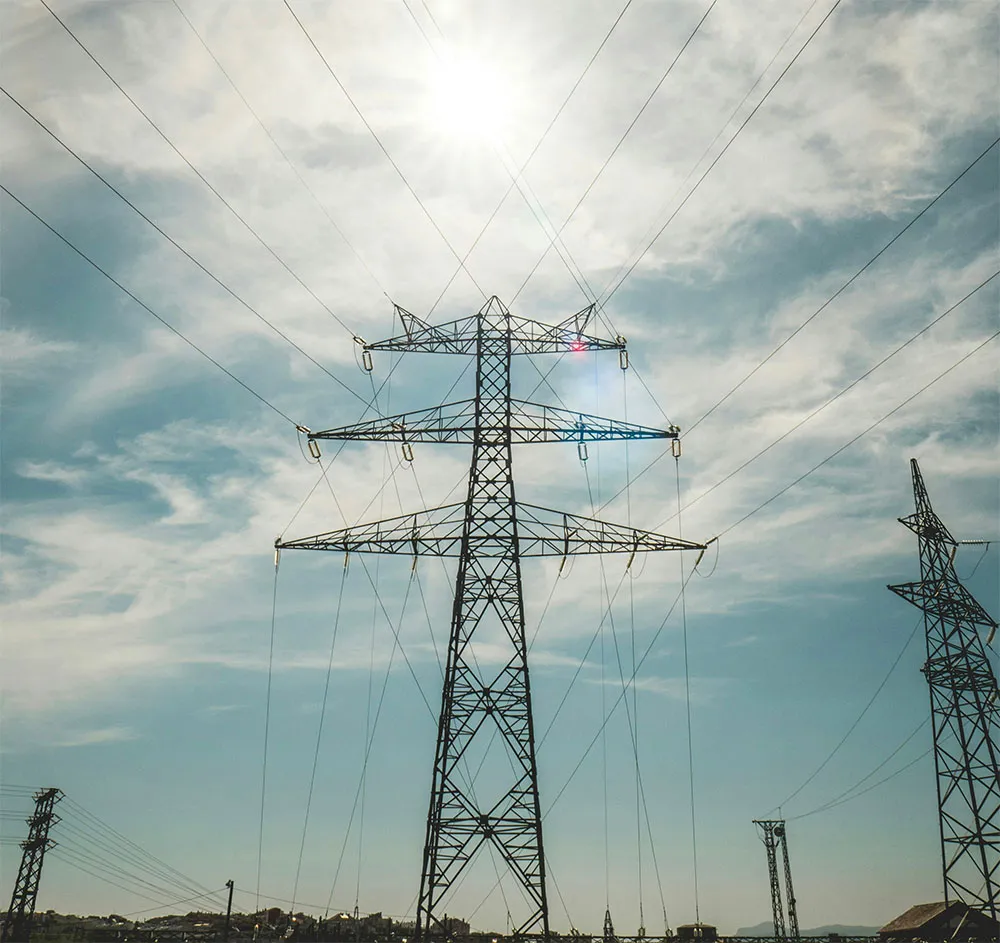 Grand poteau électrique inspecté par un drone de loin
