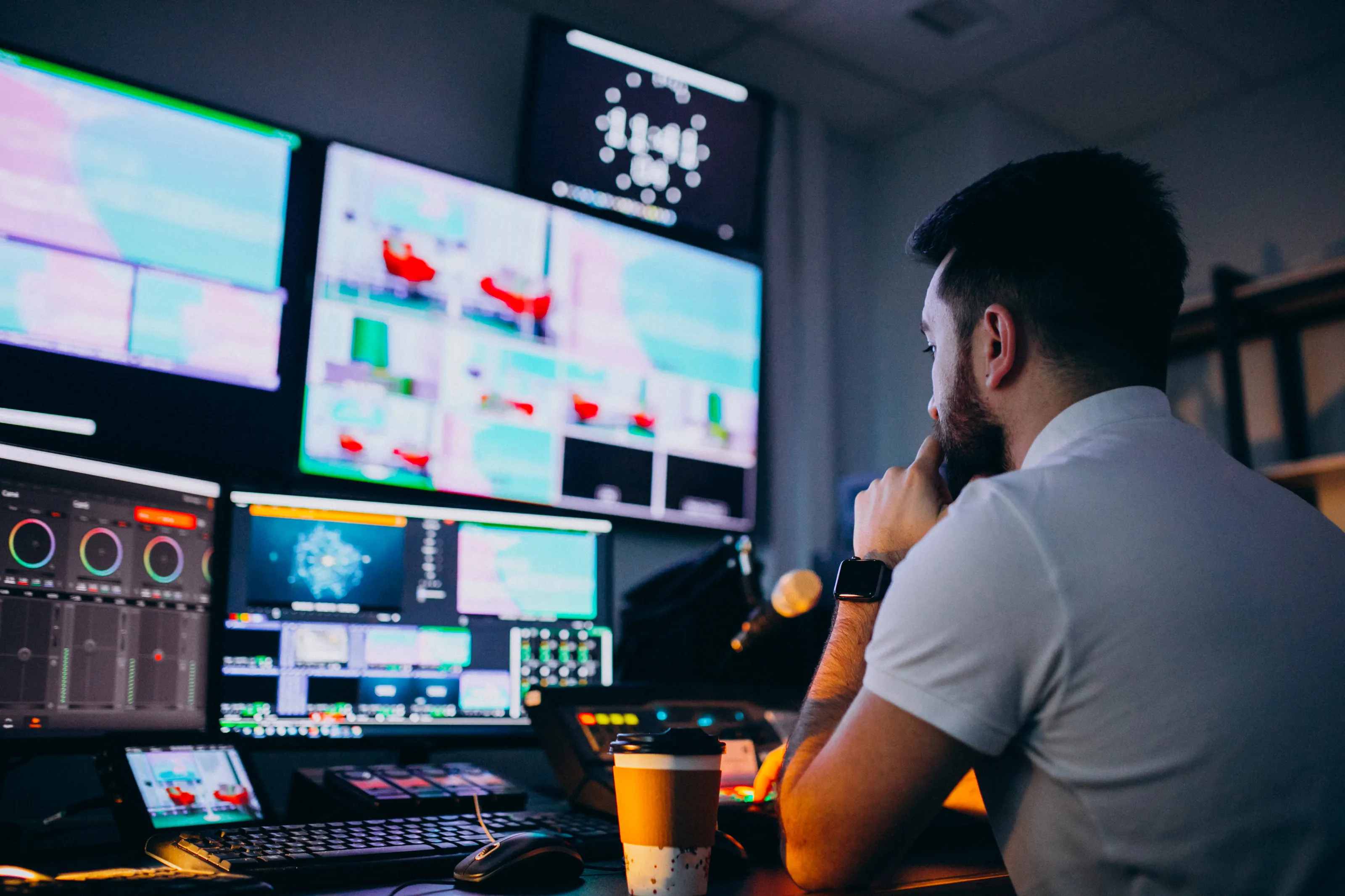 Monteur vidéo YouTube travaillant sur le montage d'une vidéo dans un studio professionnel équipé de plusieurs écrans