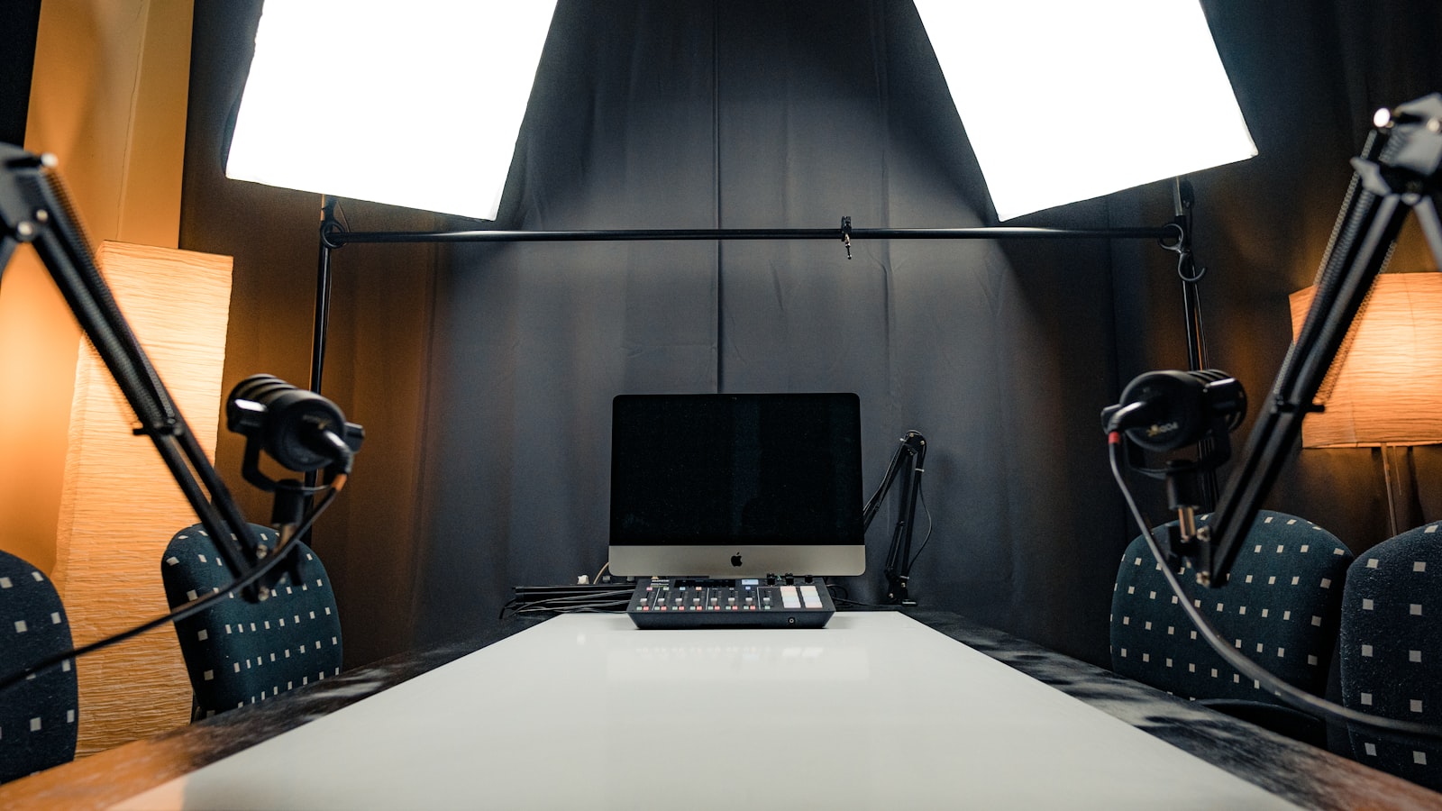 Bureau de podcast avec ordinateur portable et deux micros sur pied
