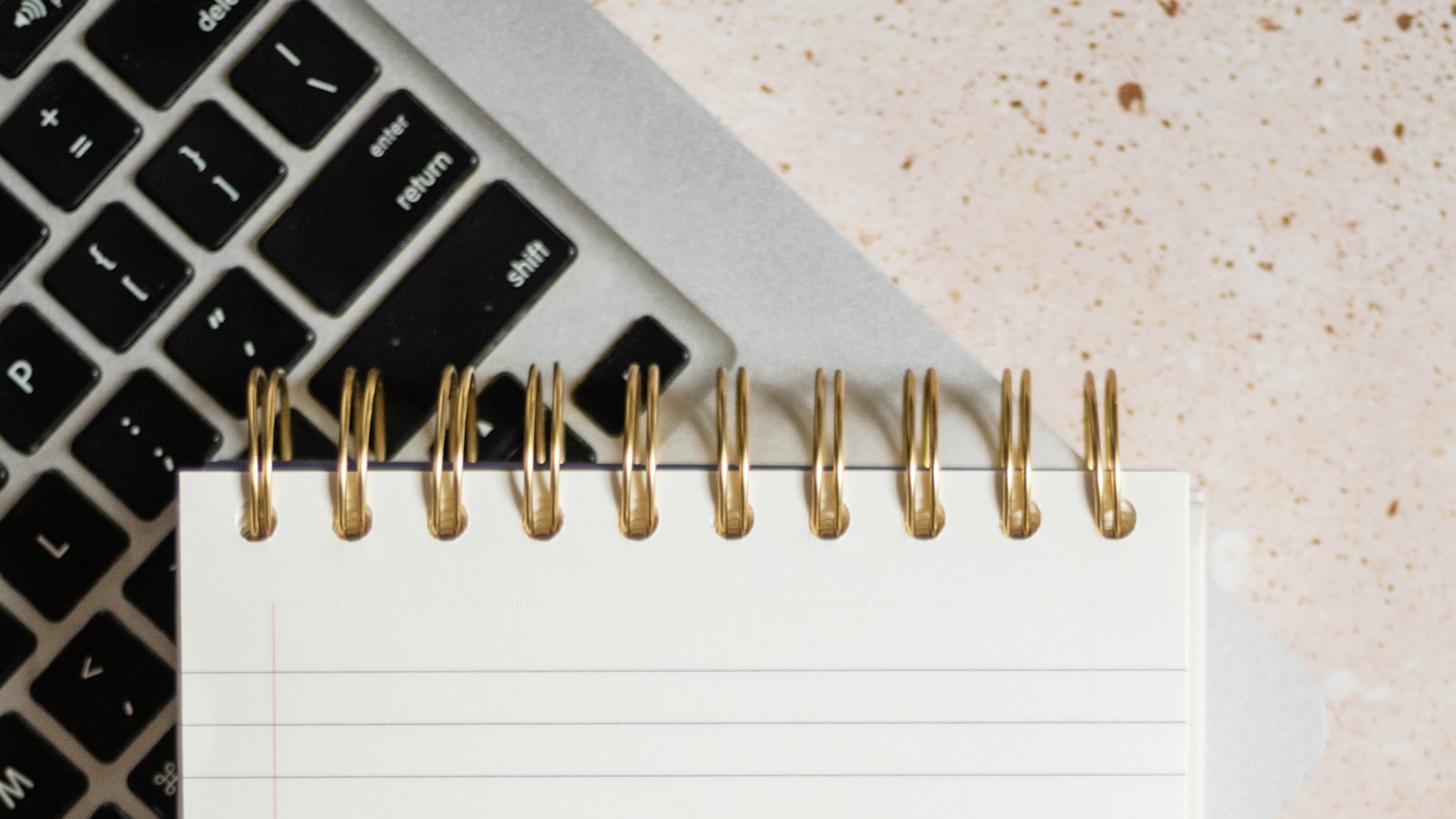 Bloc-notes posé sur un clavier pour rédiger un brief de montage