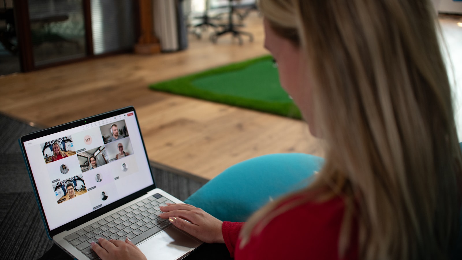 Femme en appel vidéo devant un ordinateur portable en télétravail