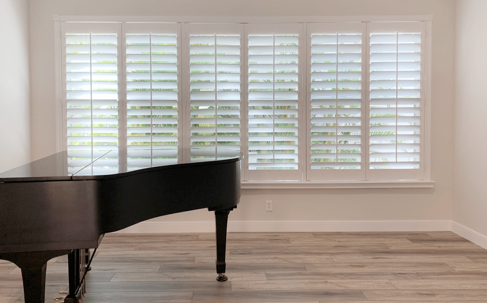 Real-wood plantation shutters in a grand Palm City, FL living room with a piano
