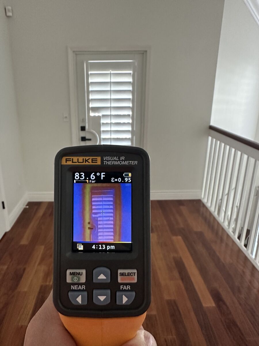 IR thermometer reading 83.6°F on same door with APS plantation shutters closed