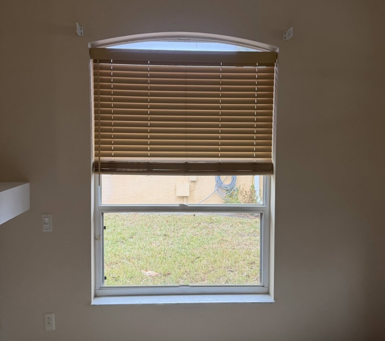 Bare arched window in a Port St. Lucie area home before plantation shutters were installed
