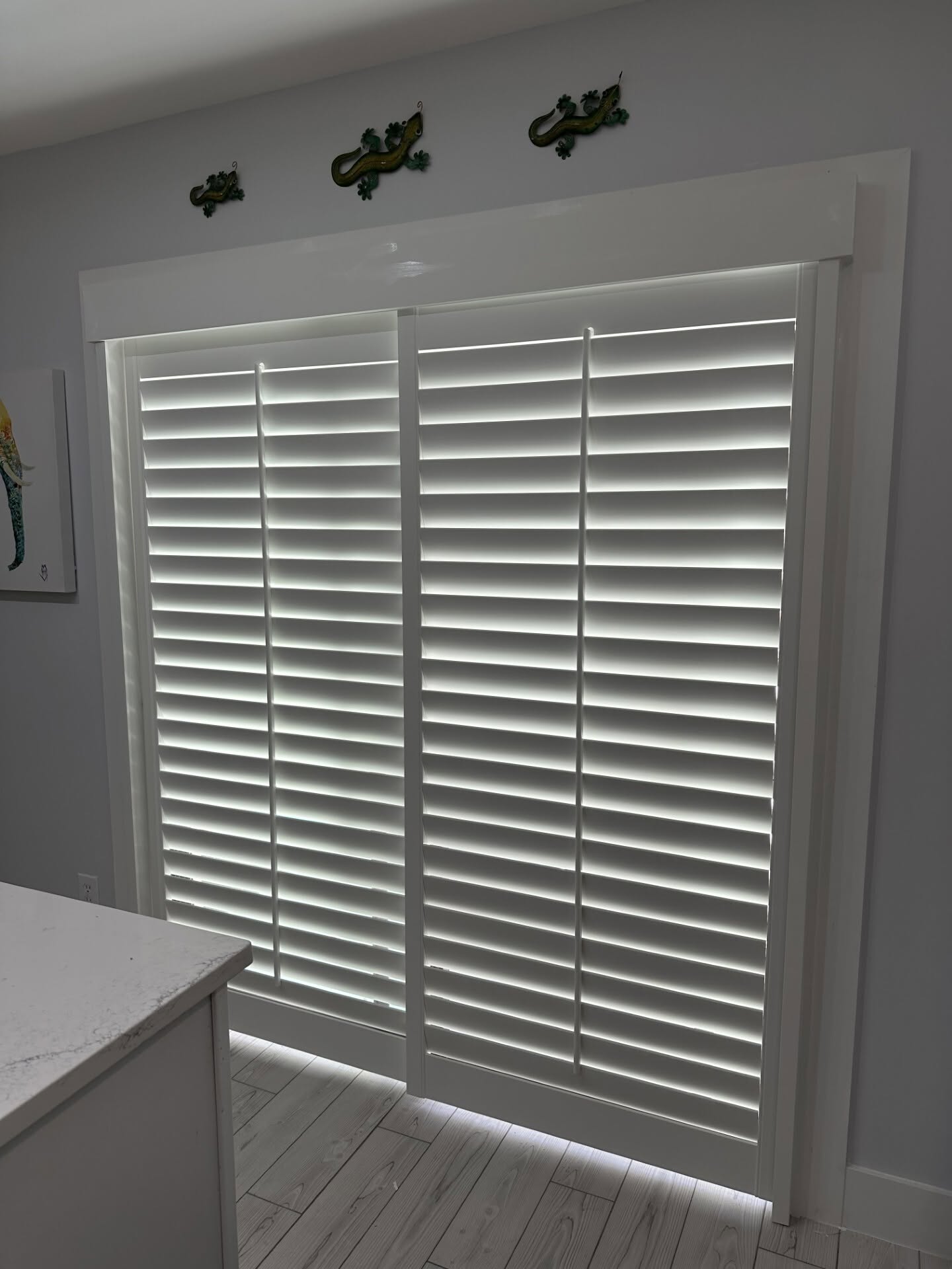 Custom real-wood plantation shutters on sliding glass doors in a Tradition, Port St. Lucie kitchen