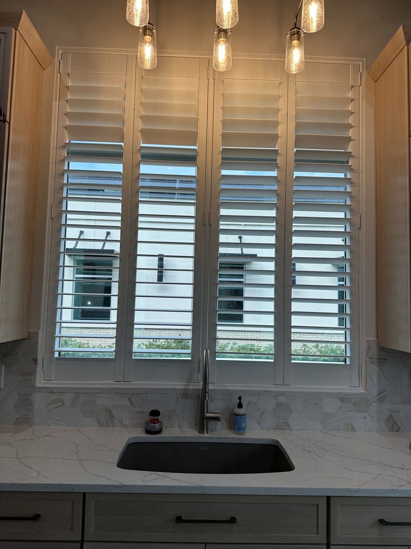Custom real-wood plantation shutters installed in a kitchen