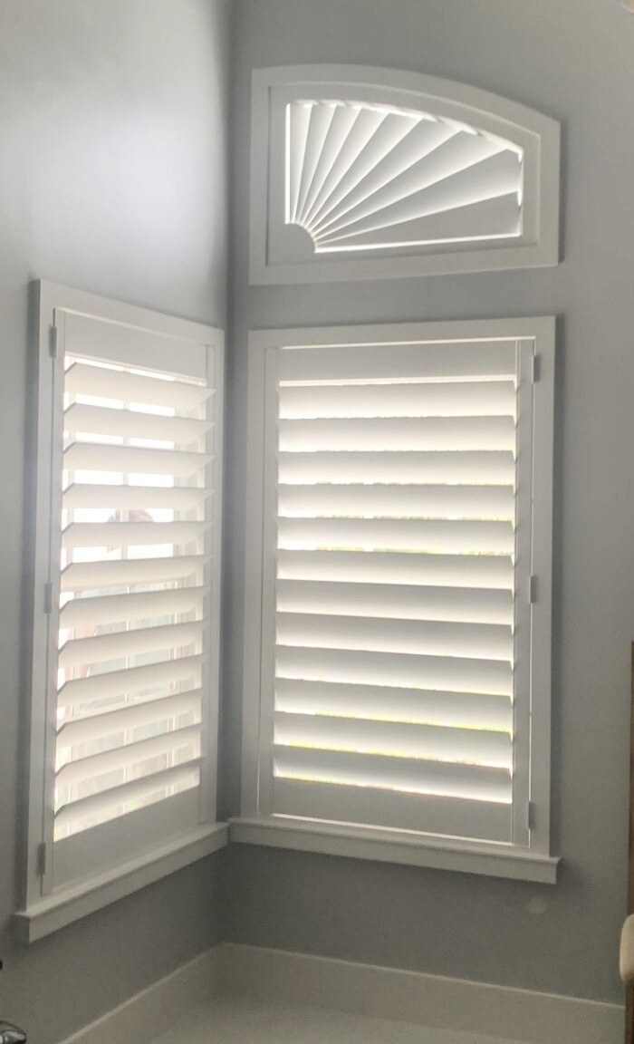 Asymmetrical partial sunburst fan shutter fitted above a corner window