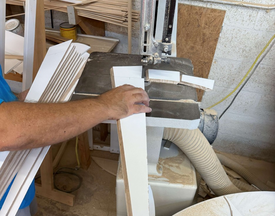 AP Shutters craftsman shaping an individual hardwood sunburst shutter component at the bandsaw