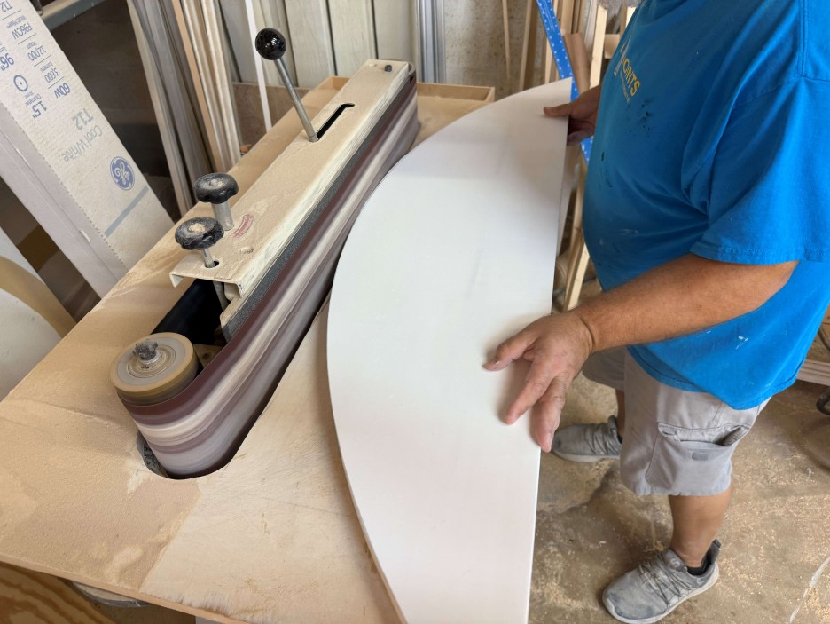 AP Shutters craftsman refining the outer curve of a hardwood sunburst frame blank