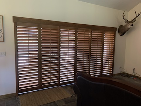 Six narrow stained louvered fields across a wide living-room opening