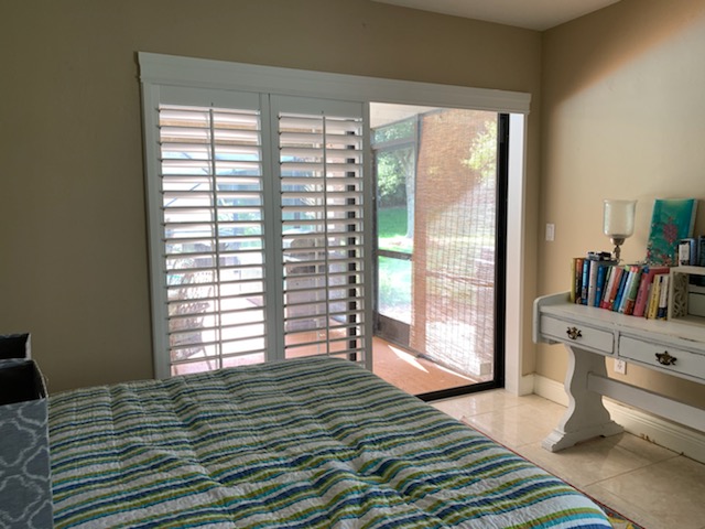 White shutter leaves gathered left with glass exposed on the right of a bedroom opening
