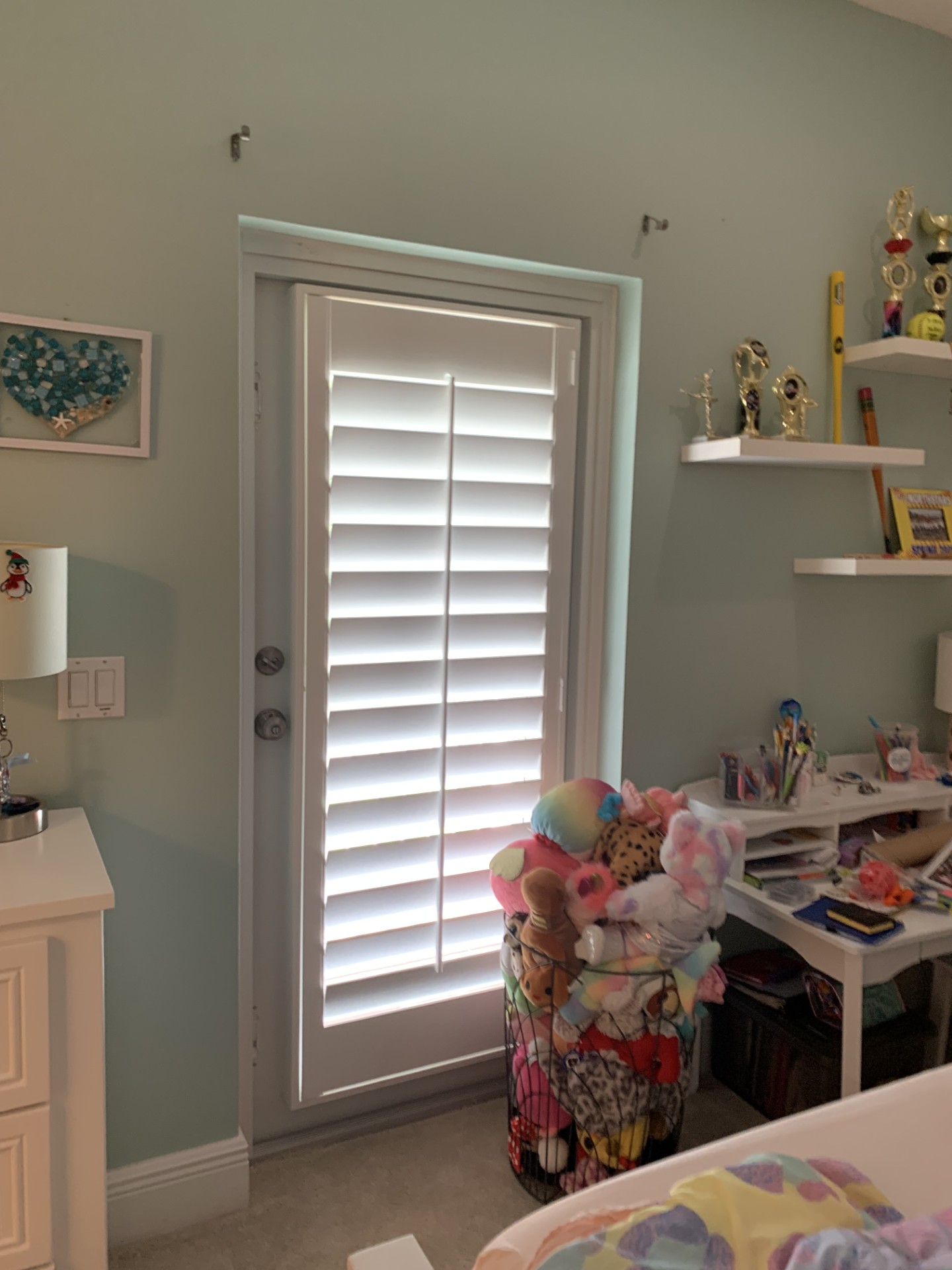 White plantation shutter on a bedroom glass door with a straight frame beside the lock