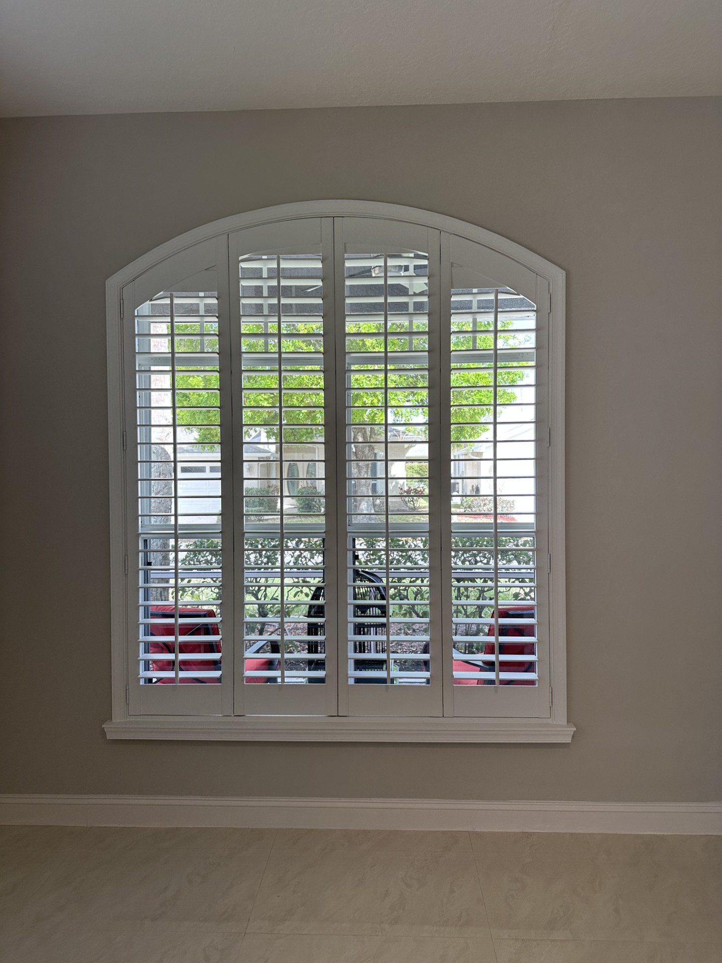 Three louvered shutter panels following a wide shallow arch