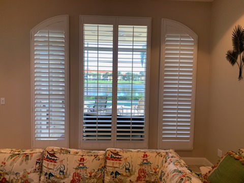 Curved side shutter panels beside rectangular central shutters in a window group