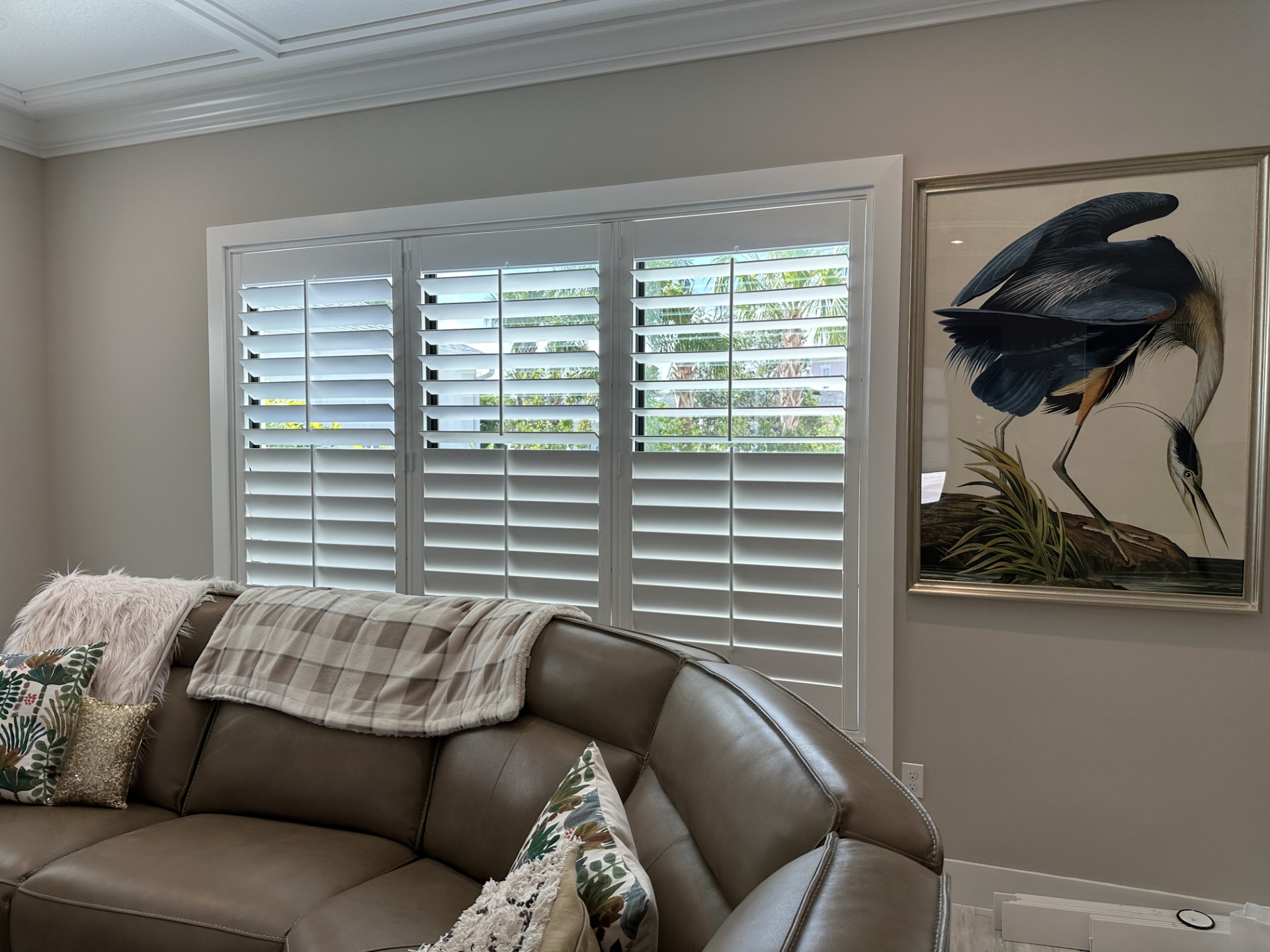 White wood plantation shutters completing a bright living room in an AP Shutters installation
