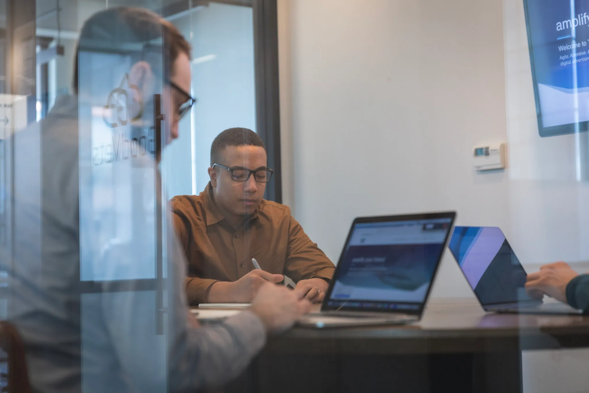 a person sitting at a desk with a laptop