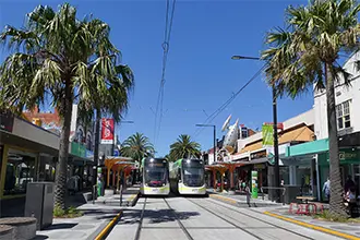 a photo of acland street in st kilda with shops and trams