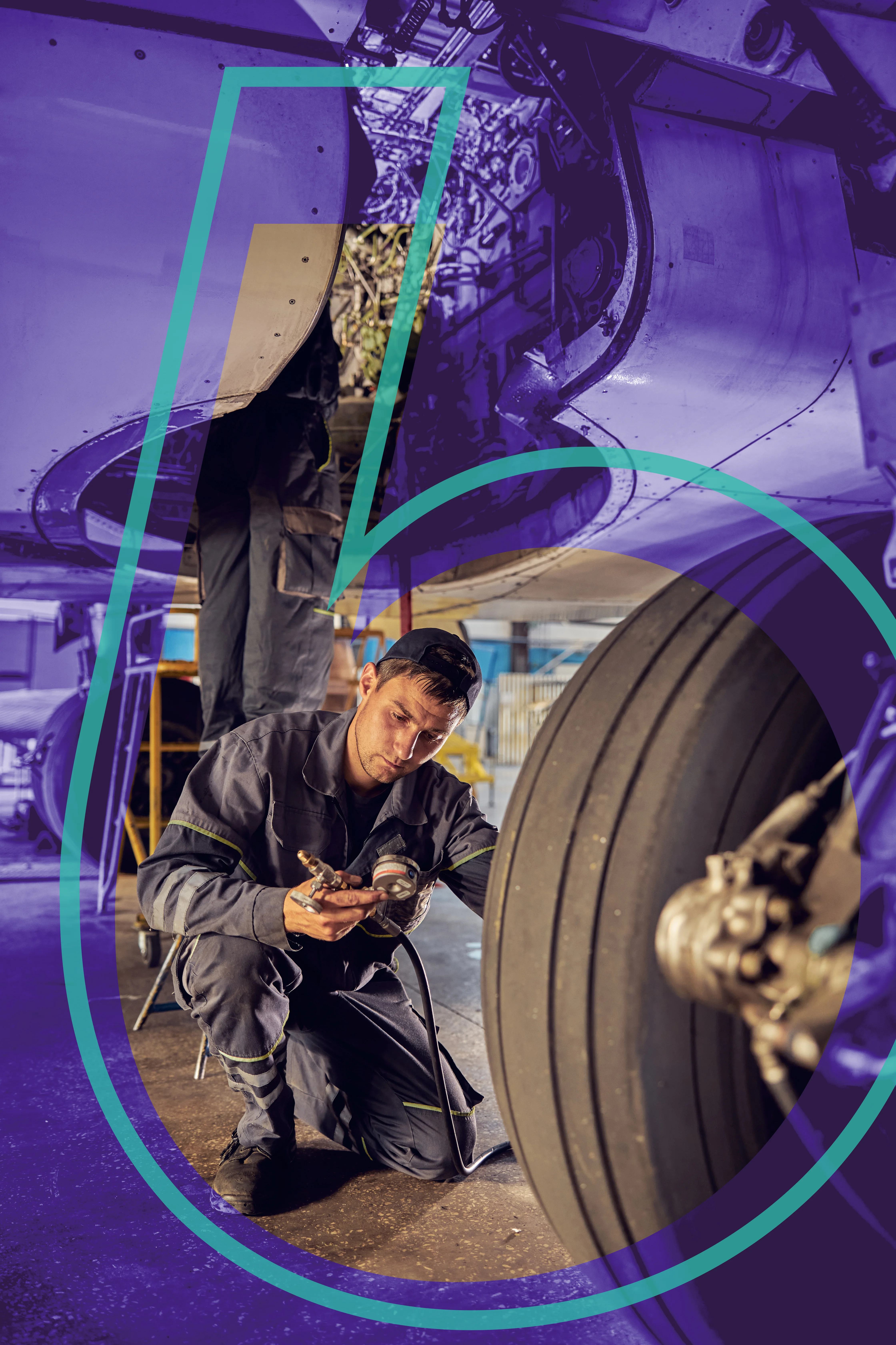 Aircraft mechanic wearing a cap and jumpsuit kneeling and inspecting a large airplane tire with a pressure gauge inside an aircraft hangar.