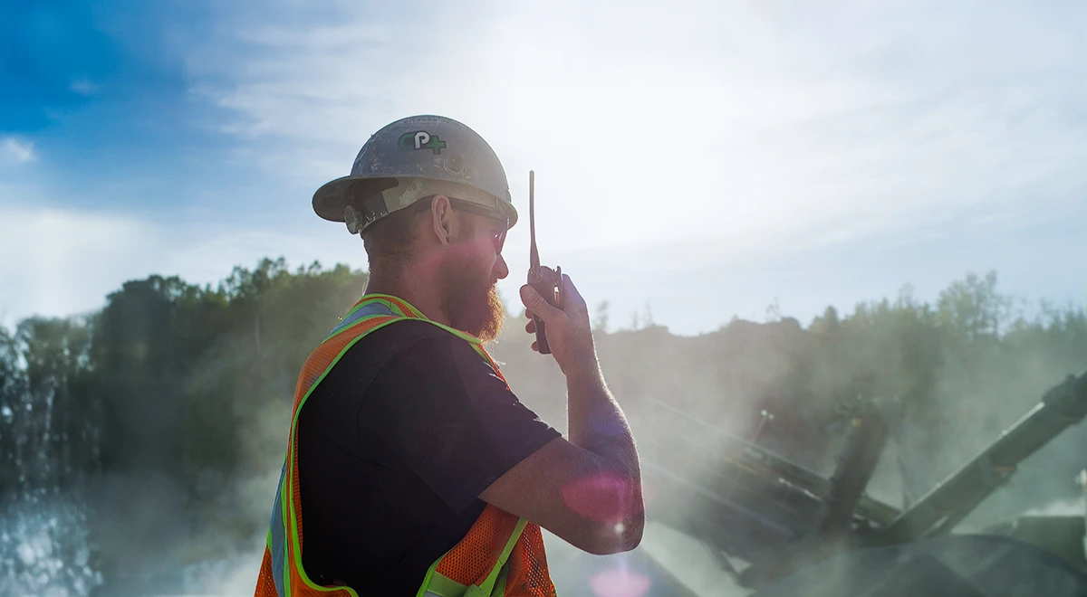 Employé Concassage plus sur chantier – communication radio et sécurité terrain.