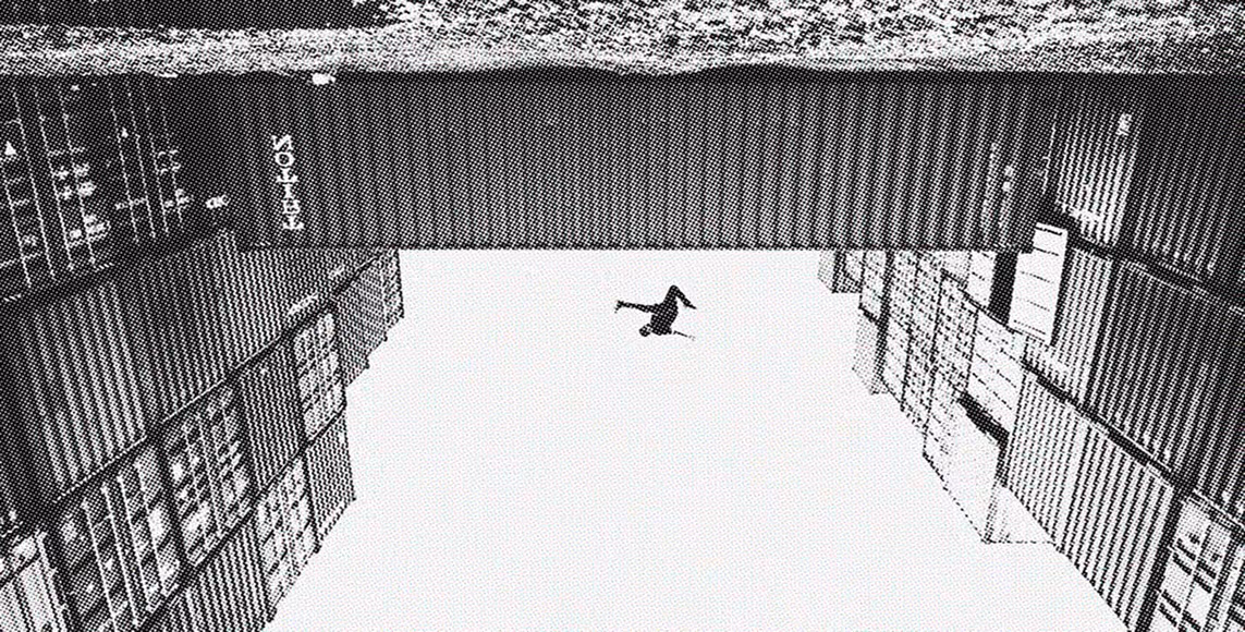 Black-and-white photo taken from below, showing a person mid-air upside down between tall buildings.
