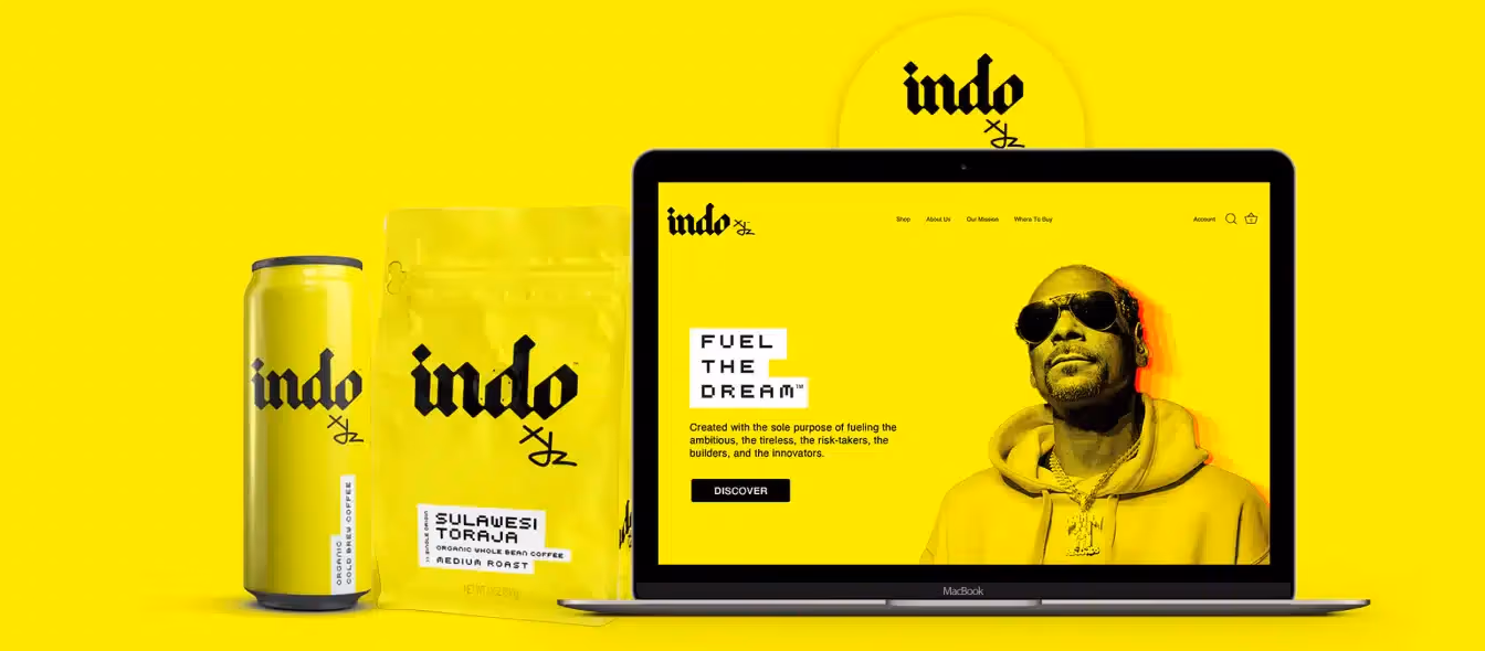 Yellow-themed Indo coffee branding showing a can, a coffee bag labeled Sulawesi Toraja, and a laptop displaying the Indo website with a man wearing sunglasses.