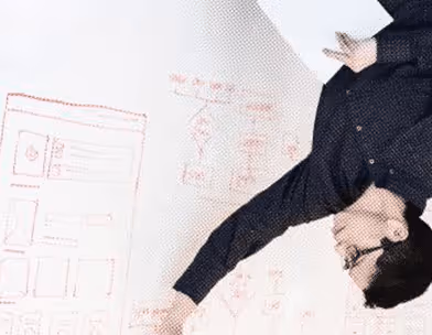 Person pointing to diagrams and notes on a whiteboard, holding a sheet of paper.