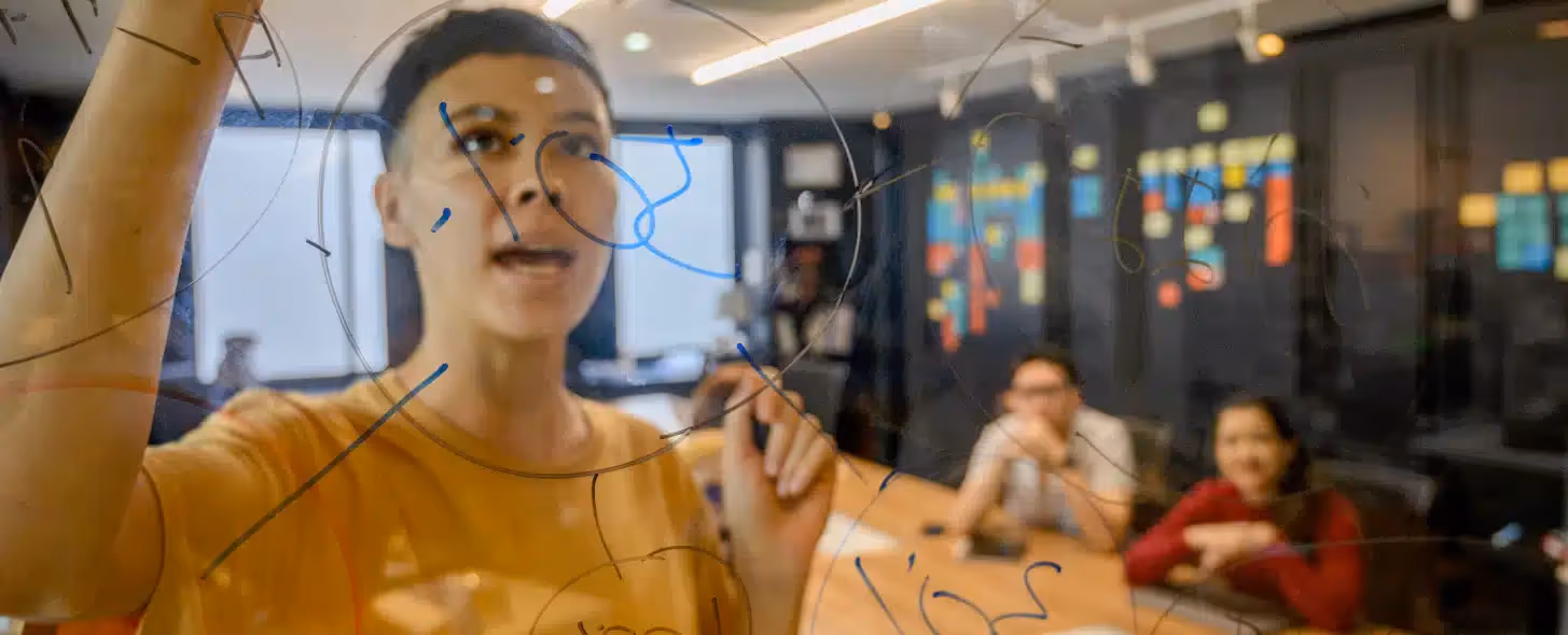 A man writing on a transparent board 