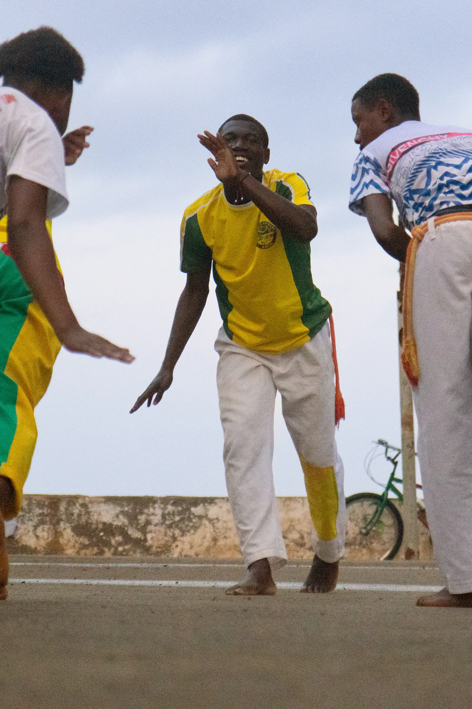 Group of capoeira players practicing together on a seaside street in São Tomé.