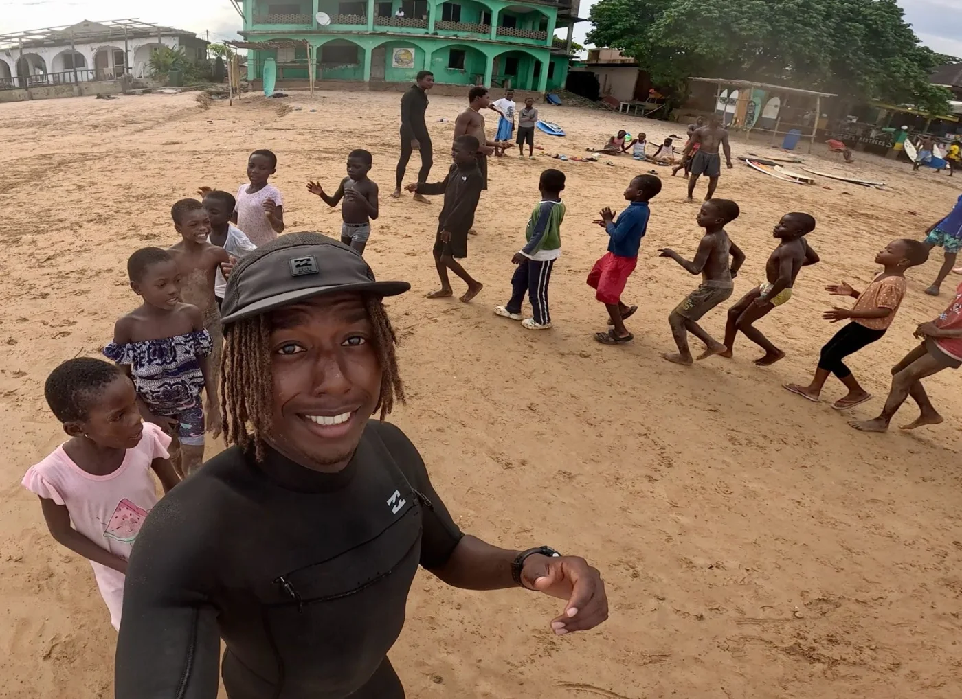 Fayed on the sand at Busua, a line of children behind him mid beach-training session.