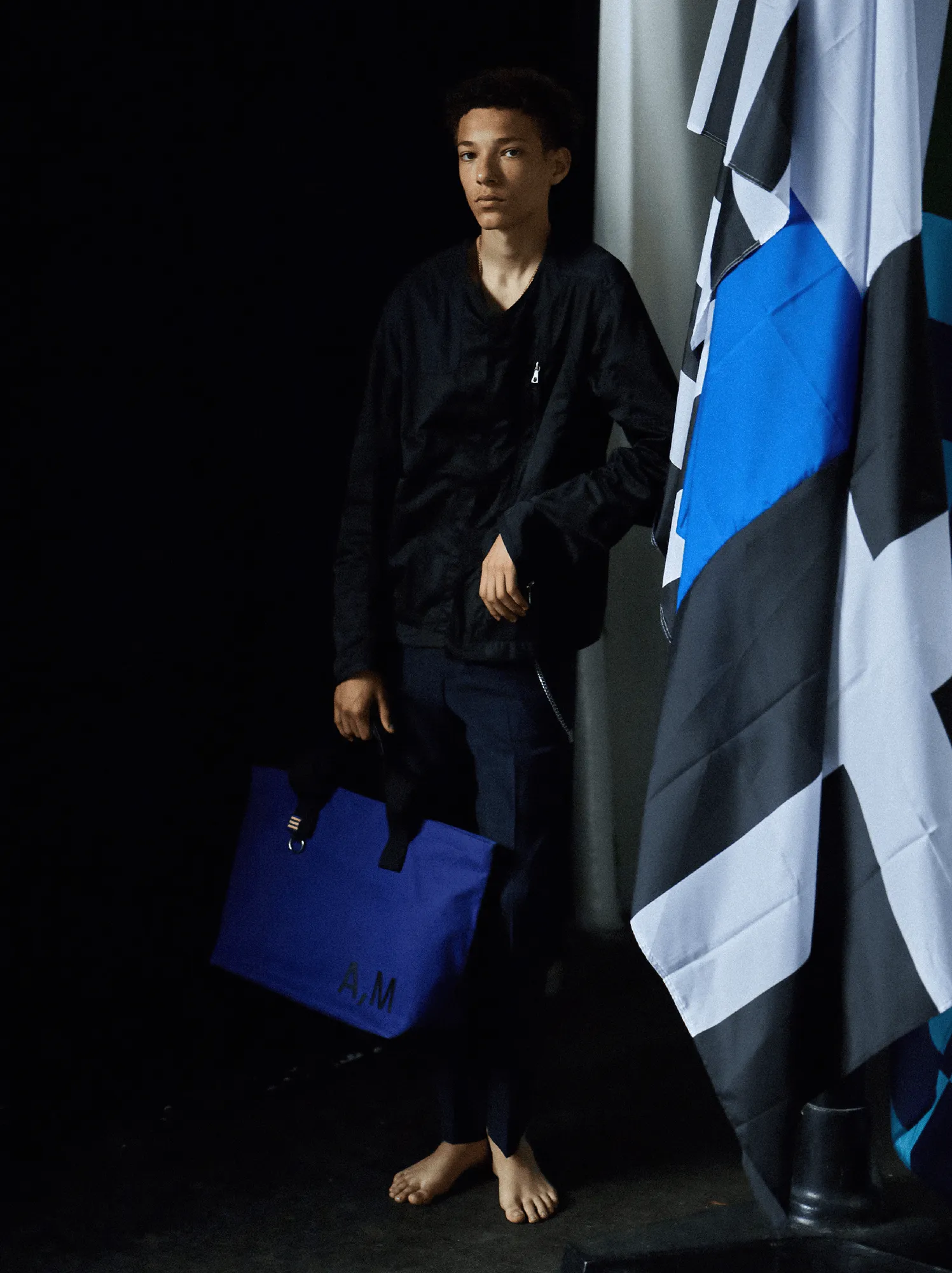 Full body portrait of a young man next to a big flag