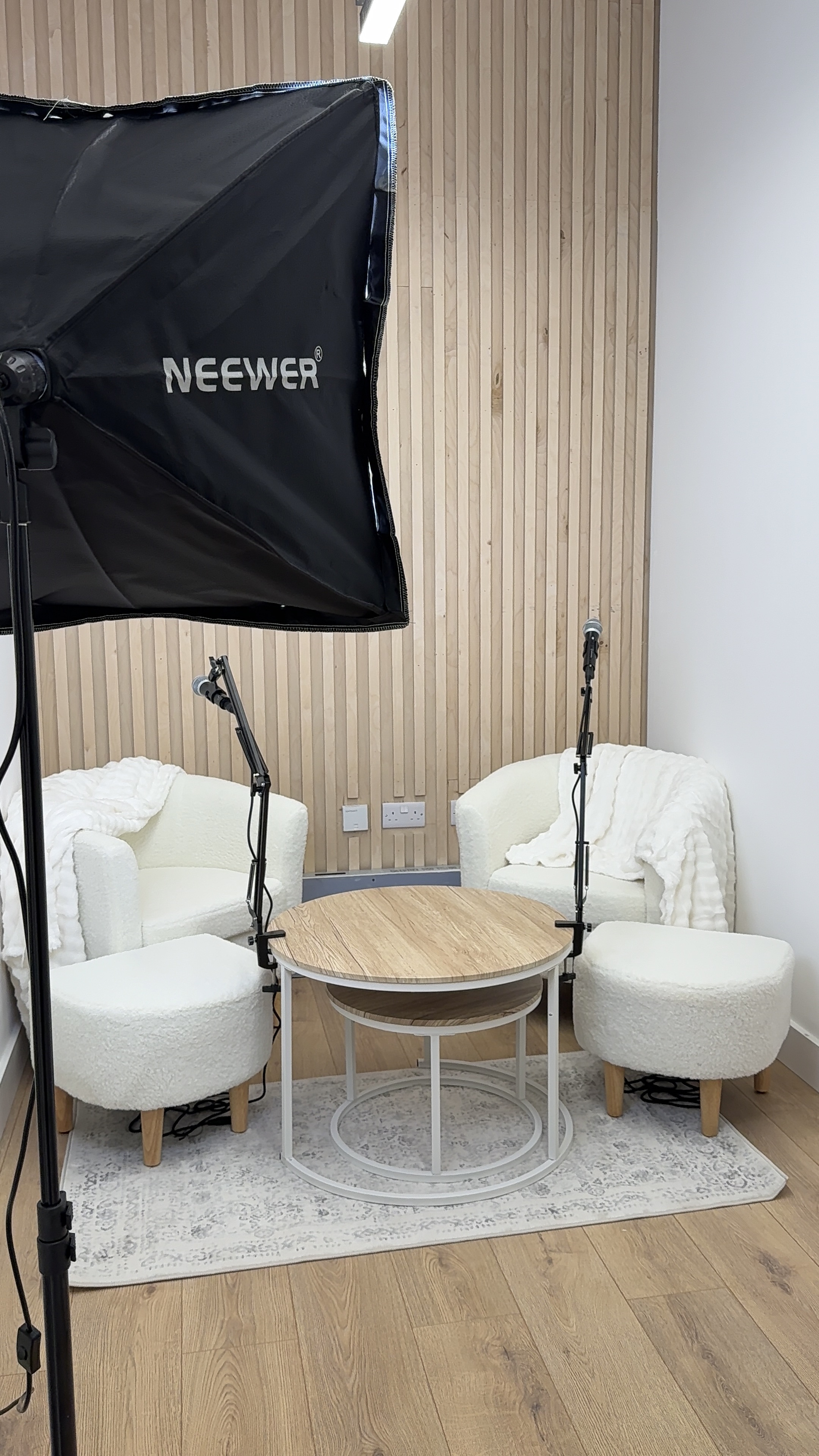 podcast room of risen studio with white couches and a table