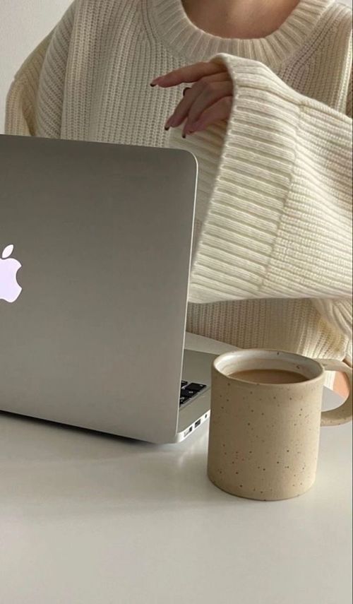 a girl using apple laptop and a coffee mug on the table