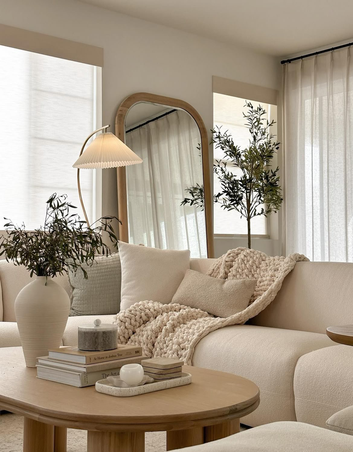 a podcast room with cream sofas, a lamp and a table
