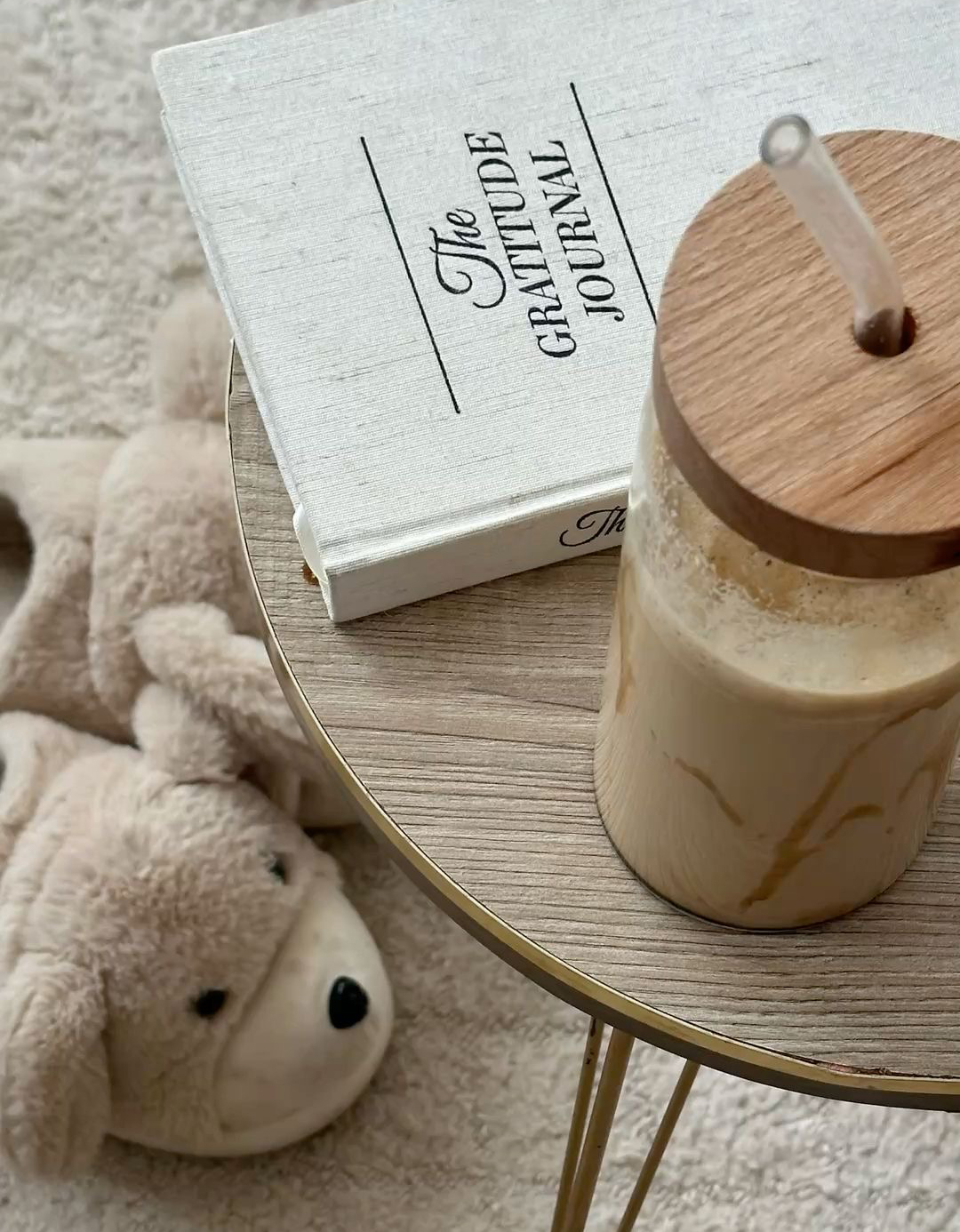 a bear on the floor, coffee jar on the table with a book