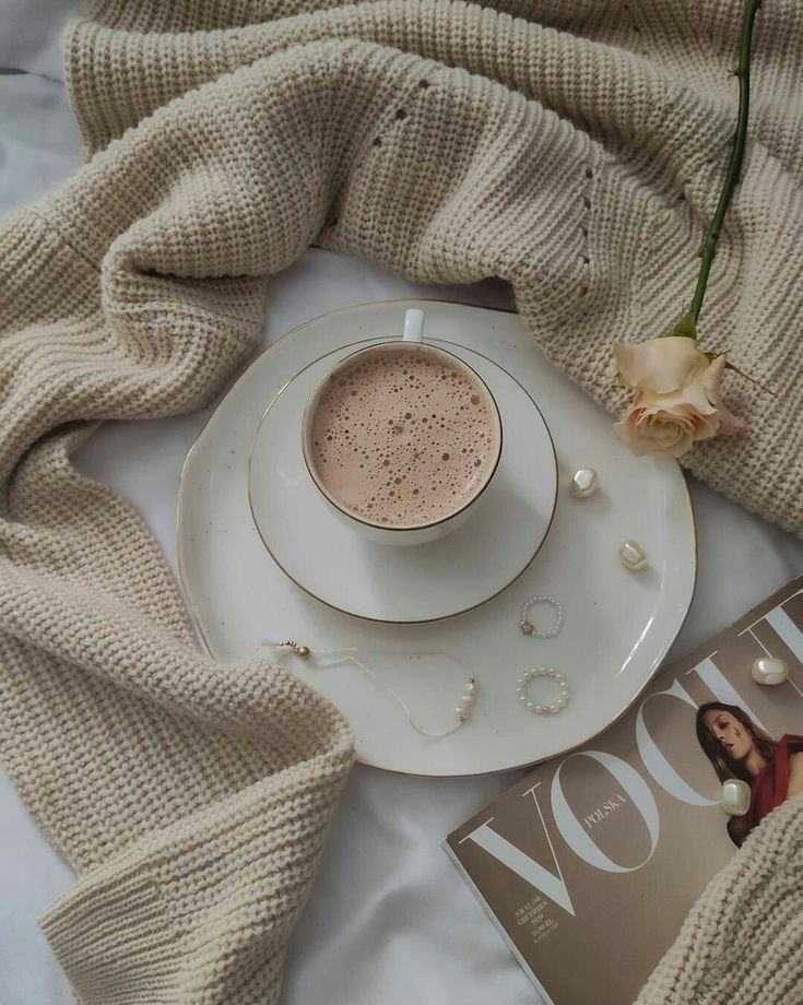 a coffee with vogue magazine beside with a blanket
