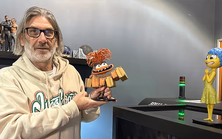 Jason Lopes holding a 3D-printed model of the character Anxiety from the movie Inside Out 2.