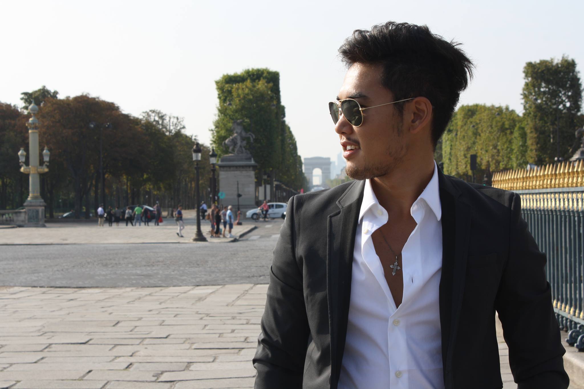 Photographie de Kazu en costume, devant les Champs-Elysées et l'arc de triomphe, 2014, Paris.