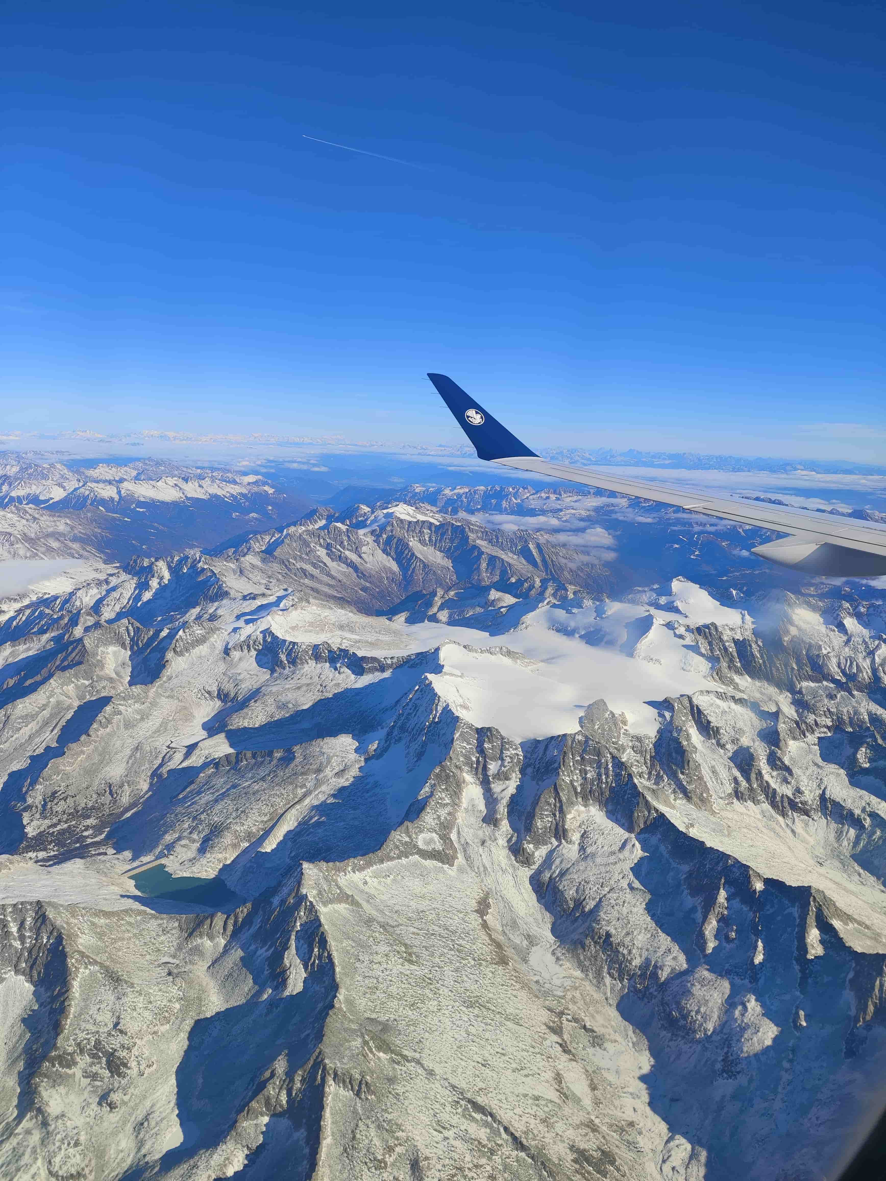 Vue aérienne des montagnes des Alpes avec la lumière du Soleil diffuse qui se reflète sur le blanc de la neige comme le Rouge Levant.