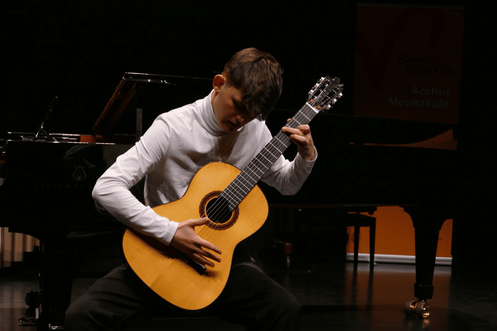 Ældre billede af Johan i sort hvid hvor han spiller guitar